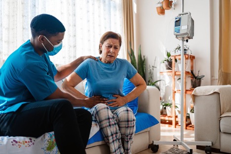 A photo of a doctor and a woman patient with abdominal pain having a medical exam